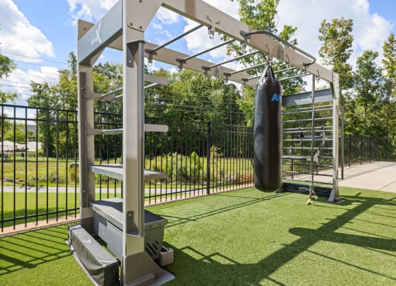 a punching bag in fenced in area with a wrought iron fence