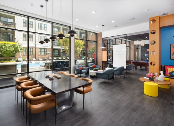 a communal area with a table and chairs and a large window