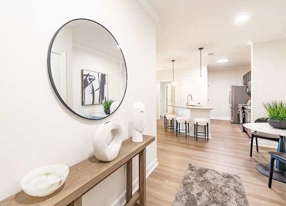 A modern kitchen with a round mirror on the wall.