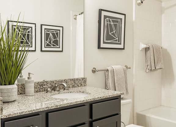 A bathroom with a white toilet and a sink with a counter top.
