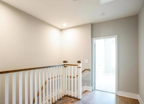 Modern Two-Story Apartment Interior Featuring Open Railing and Natural Light