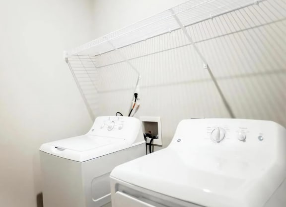 In-Unit Laundry with Full-Size Washer and Dryer and Overhead Wire Shelving