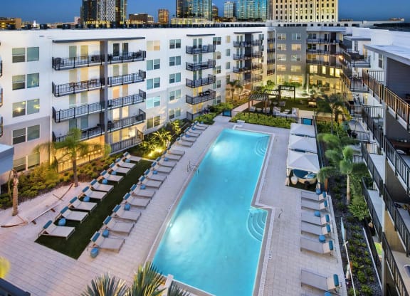 Aerial Poolside Scene with City Skyline Views and Illuminated Courtyard
