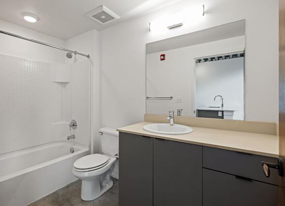 A white toilet sits next to a bathtub in a bathroom.