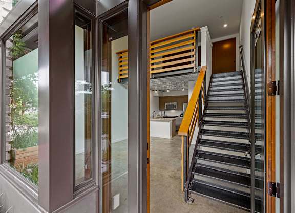 A staircase with a metal railing and wooden handrails.
