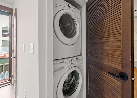A modern washing machine is built into a wooden door.