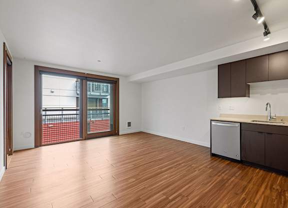 A kitchen area with a sink and a refrigerator.