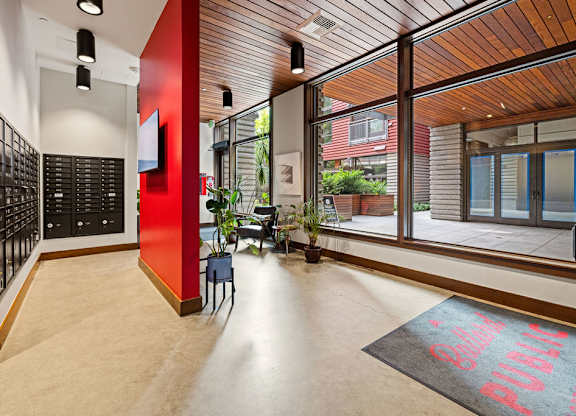 A hallway with a red wall and a black and white checkered floor.