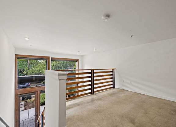 A white room with a window and a balcony.