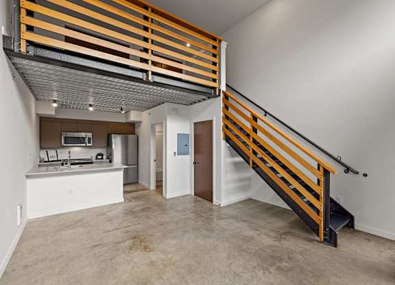 A modern kitchen with a wooden staircase.
