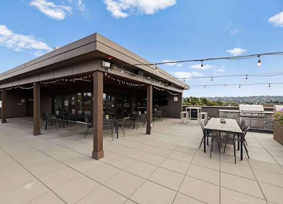 A patio with a table and chairs under a roof.