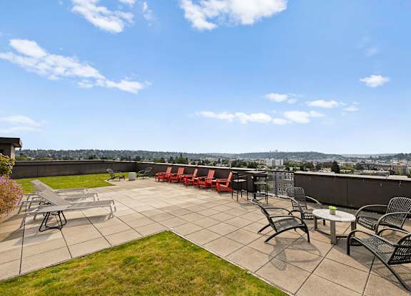 A patio with a table and chairs overlooking a city.