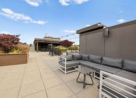 A patio with grey couches and a table.