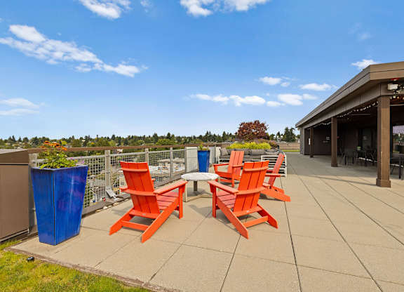 Four orange chairs are arranged on a patio.