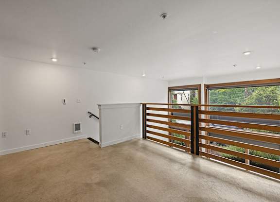 A room with a sliding door and a window with a view of trees.