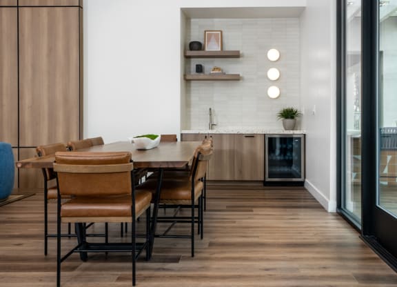 a dining room and kitchen with a wooden table and chairs