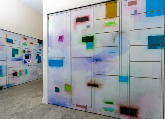 a series of lockers with paintings on them in a room