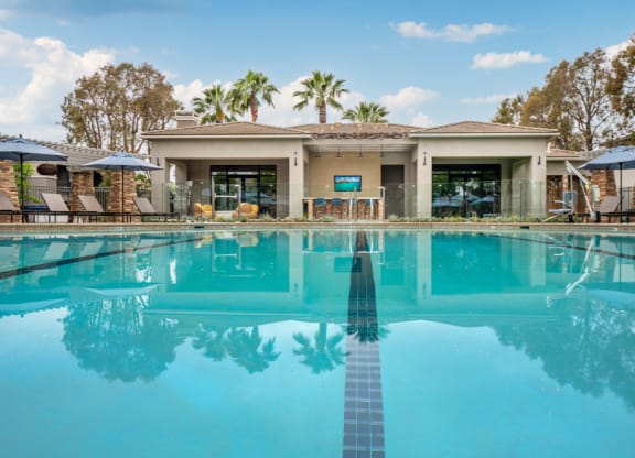 a large swimming pool with a house in the background