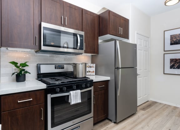 1-Bedroom Apartments in Rancho Cucamonga, CA - Camino Real - Gourmet Kitchen with Stainless Steel Appliances, White Countertops, and Wood-Style Flooring