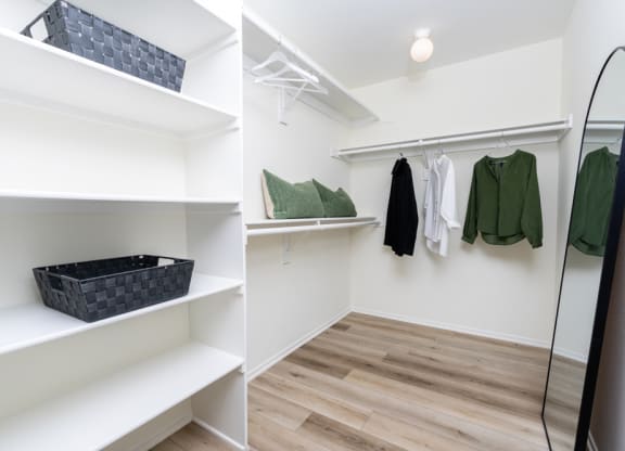 two pictures of a walk in closet with shelves and a mirror