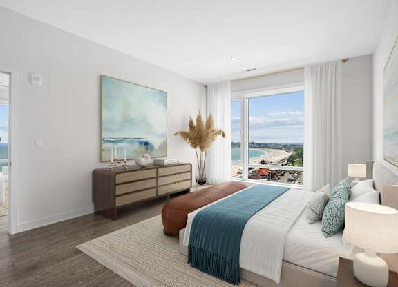 Penthouse bedroom with hardwood-style flooring, a dresser and a wide corner window over the beach and boulevard.