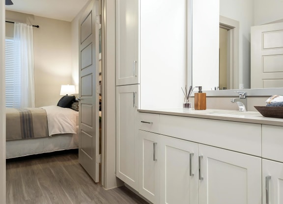 Connected Bathroom Featuring Double Vanity and Linen Cabinet