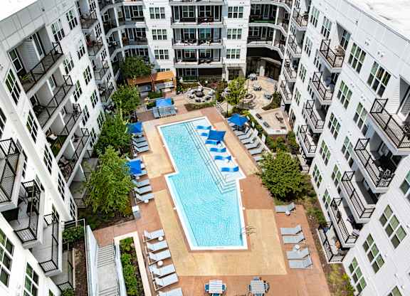 A large swimming pool surrounded by apartment buildings.