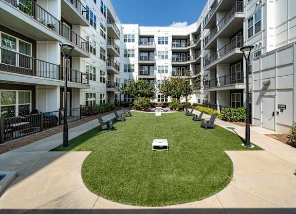 A grassy area in front of apartment buildings.