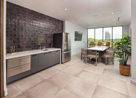 A kitchen with a tile backsplash and a dining table with chairs.
