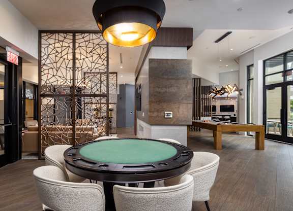 A modern dining room with a glass table surrounded by chairs.