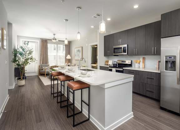 A modern kitchen with a white island and stainless steel appliances.