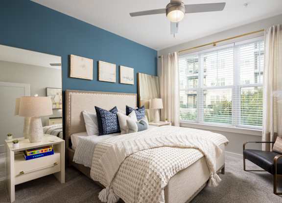 A bedroom with a large bed and a ceiling fan.
