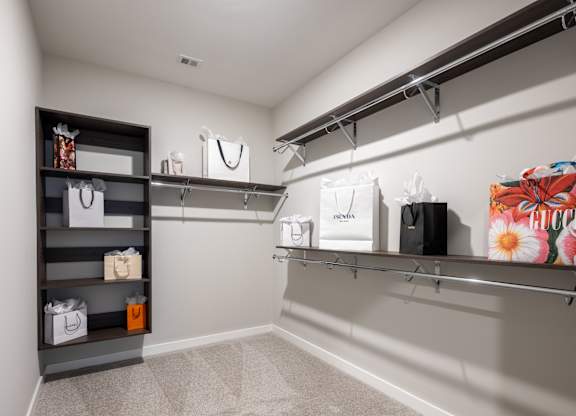A walk-in closet with clothes hanging on racks and shelves.