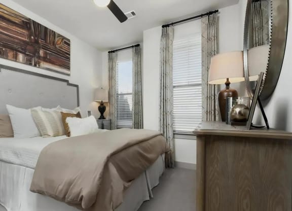 Bedroom with Bed, Dressers, Lamps, and Wall Art Above Headboard