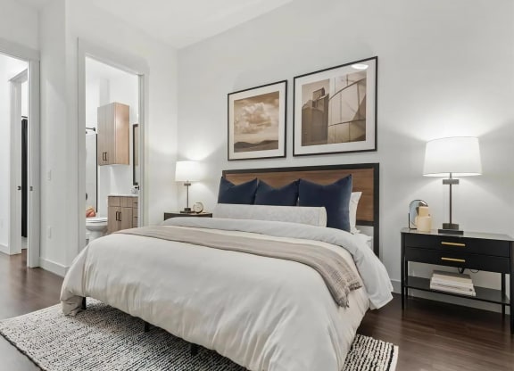 Apartment Bedroom with Open Bathroom View and Wood Flooring