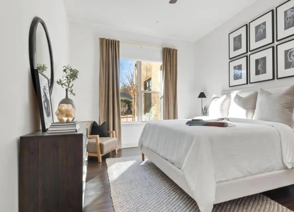 Bright Bedroom with Large Window, Wall Decor, and Dresser