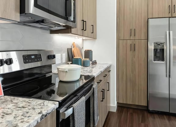 Kitchen Featuring Granite Countertops, Stainless Appliances, and Cabinets