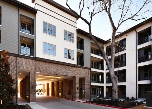 Covered Apartment Entry with Warm Brick Detailing and Balcony Views