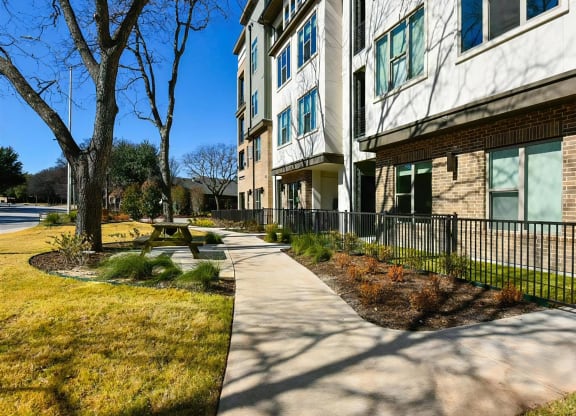 Outdoor Walking Path with Trees, Benches, and Apartment Views