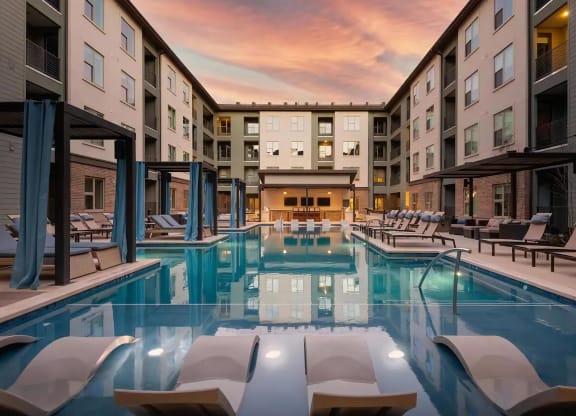 Peaceful Sunset Over Courtyard Pool Featuring Lounge Seating and Cabanas