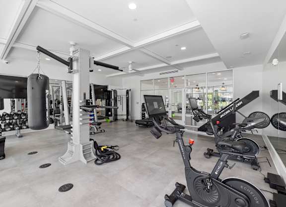A gym with a variety of equipment including treadmills, weights, and exercise machines.