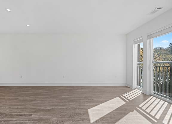 Expansive Living Room with Oversized Windows and Plank Flooring