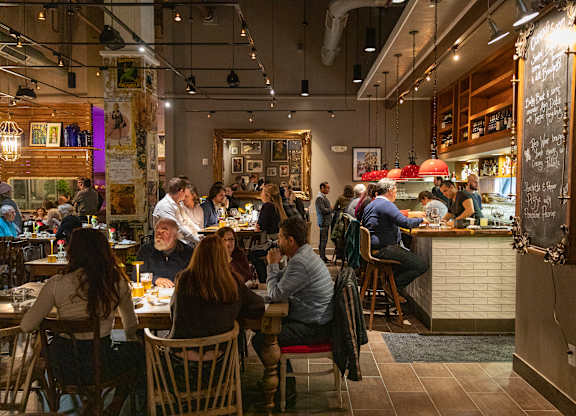 A group of people are sitting at tables in a restaurant.