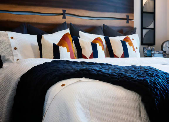 Thoughtfully Designed Bedroom with Colorful Pillows and Custom Wood Headboard