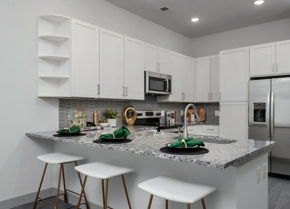 Open Kitchen Layout with White Cabinets and Stainless Steel Appliances