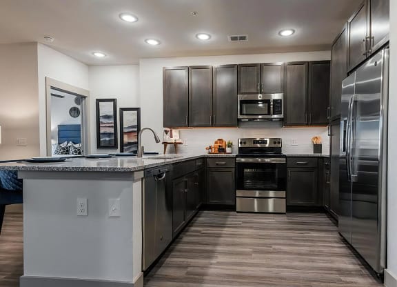 U-Shaped Kitchen with Dark Cabinetry and Granite Countertops