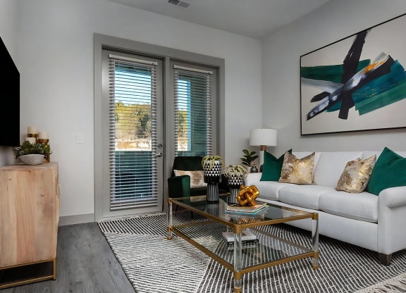 Chic Living Space Featuring White Sofa, Abstract Art, and Glass Coffee Table