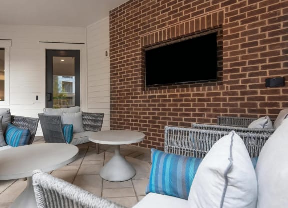 Cozy Outdoor Seating Area with Mounted TV and Modern Furniture