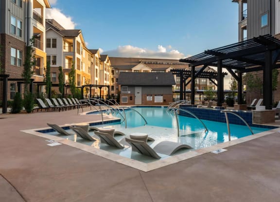 Relaxing Poolside Ambiance with Built-In Lounge Chairs at Dusk