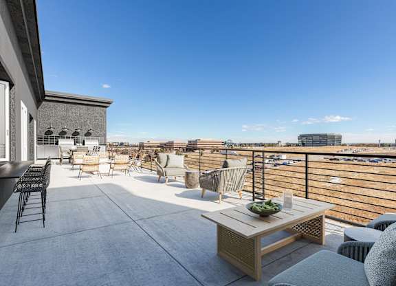 a rooftop terrace with furniture and a view of the city